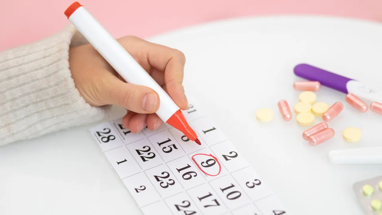 Mão marcando uma data em um calendário de papel