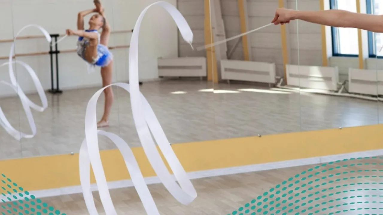 Criança usando fita de ginástica em uma sala de treinamento com espelho