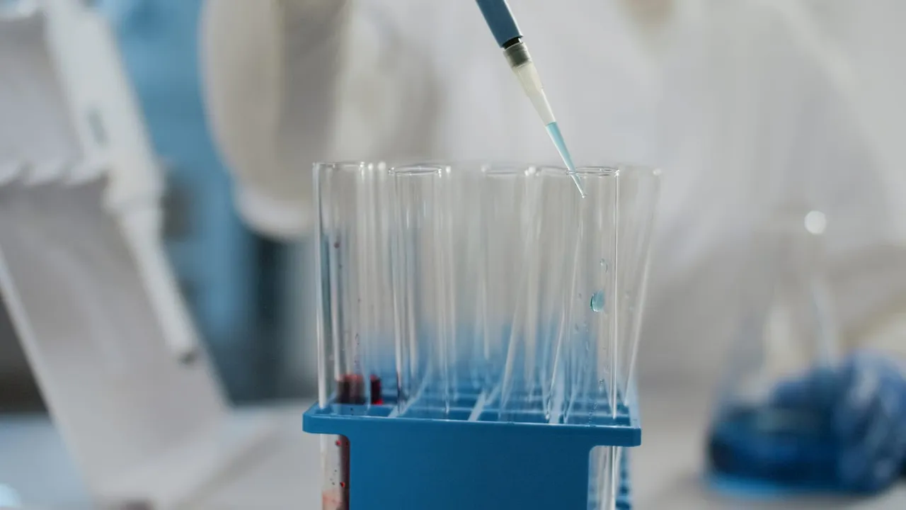 Pipeta pingando líquido em tubos de ensaio em um laboratório