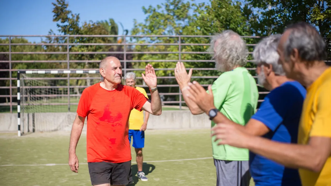 Atletas idosos se cumprimentando em um campo de futebol