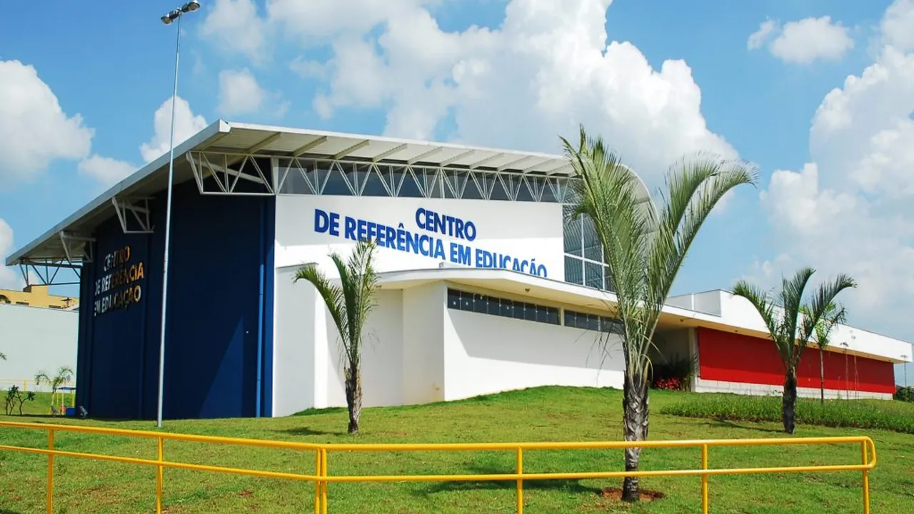 Fachada do Centro de Referência em Educação de Sorocaba, com prédio branco, azul e vermelho, gramado e palmeiras