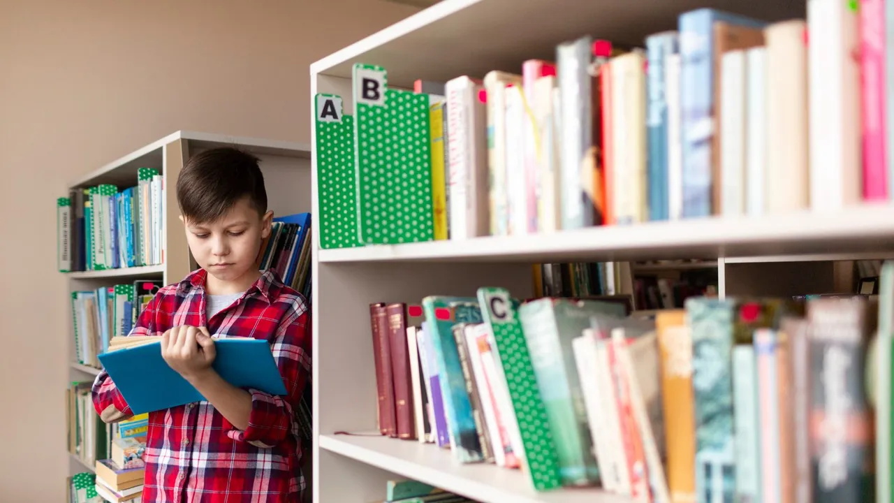 Menino lendo um livro entre estantes de uma biblioteca